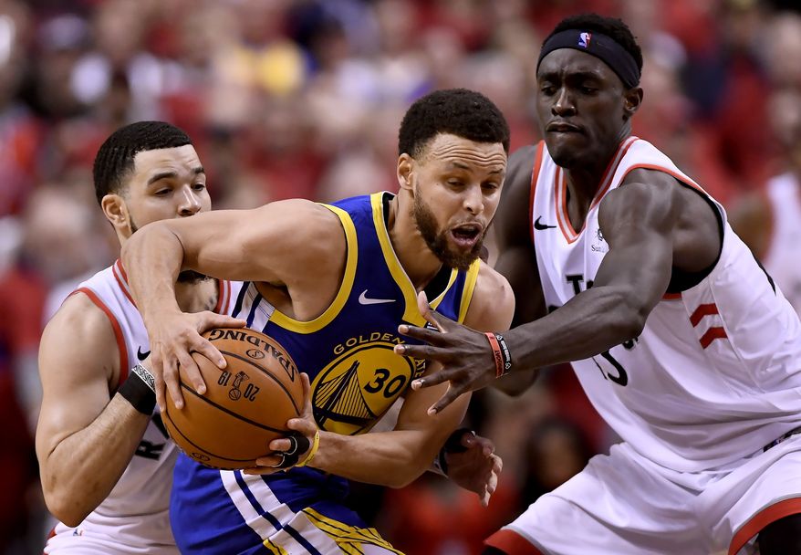 Golden State Warriors guard Stephen Curry (30) tries to fend off Toronto Raptors guard Fred VanVleet (23) and teammate Pascal Siakam (43) during the second half of Game 2 of basketballs NBA Finals, Sunday, June 2, 2019, in Toronto. (Frank Gunn/The Canadian Press via AP)