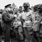 In this June 6, 1944, photo, U.S. Gen. Dwight D. Eisenhower, left, gives the order of the day to paratroopers in England prior to boarding their planes to participate in the first assault of the Normandy invasion. (U.S. Army Signal Corps via AP)