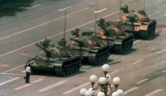 FILE — In this June 5, 1989, file photo, a Chinese man stands alone to block a line of tanks heading east on Beijing&#39;s Changan Blvd. in Tiananmen Square on Jeff Widener who created the iconic image of &quot;tank man&quot; says its time for China&#39;s government to &quot;come clean&quot; about the bloody events of June 3-4 1989. (AP Photo/Jeff Widener, File)