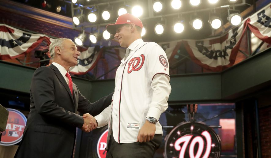 Major League Baseball Commissioner Rob Manfred, left, greets Jackson Rutledge, a right-handed pitcher from San Jacinto Junior College in Pasadena, Texas, onstage after Rutledge was elected No. 17 by the Washington Nationals in the first round of the Major League Baseball draft, Monday, June 3, 2019, in Secaucus, N.J. (AP Photo/Julio Cortez) **FILE**