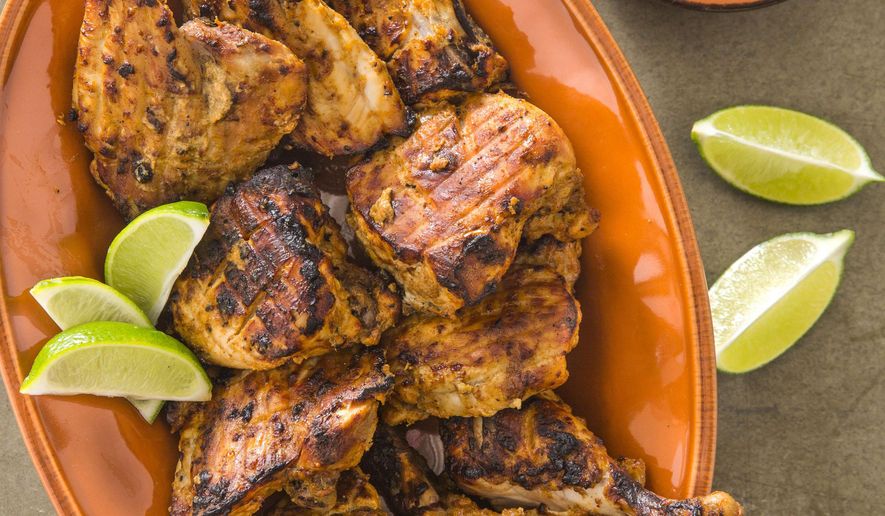 This undated photo provided by America's Test Kitchen in May 2019 shows Tandoori Chicken with Raita in Brookline, Mass. This recipe appears in the cookbook "Spiced.” (Joe Keller/America's Test Kitchen via AP)