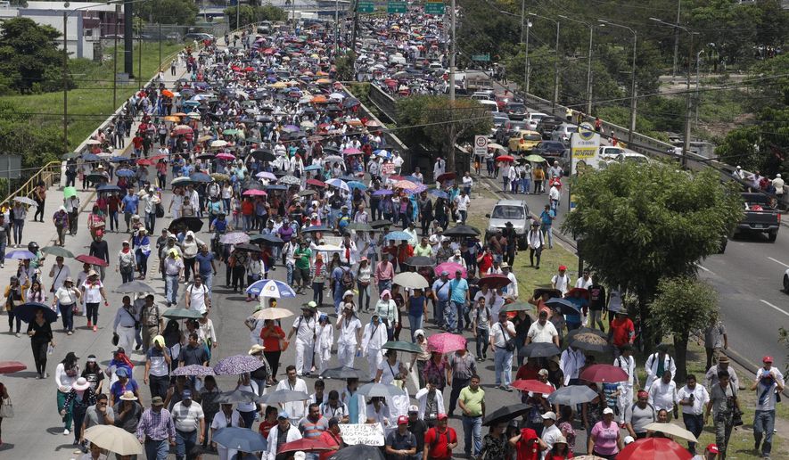 Public sector employees march to protest the government of Honduras' President Juan Orlando Hernandez, accusing Hernández of trying to privatize the health and education systems, in Tegucigalpa, Honduras, Monday, June 3, 2019. Teachers and doctors are continuing street protests despite the president's cancellation of decrees they feared would lead to extensive layoffs. (AP Photo/Elmer Martinez)