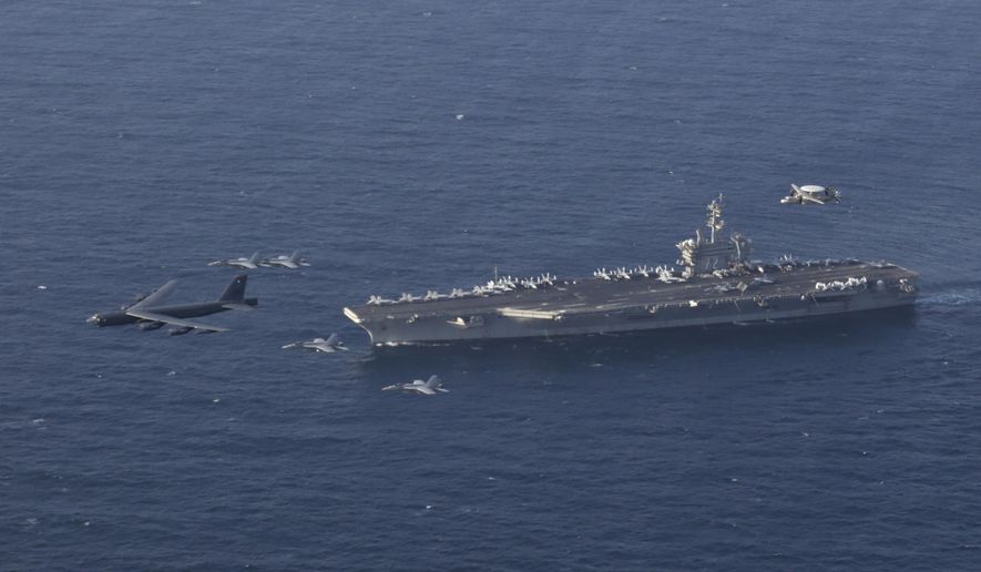 FILE - In this June 1, 2019 file photo, the USS Abraham Lincoln carrier and a U.S. Air Force B-52H Stratofortress, conduct joint exercises in the U.S. Central Command area of responsibility in Arabian sea. The Abraham Lincoln that the White House ordered to the Mideast over a perceived threat from Iran remains outside of the Persian Gulf amid efforts to de-escalate tensions between Tehran and Washington. (Mass Communication Specialist 1st Class Brian M. Wilbur/U.S. Navy via AP, File)