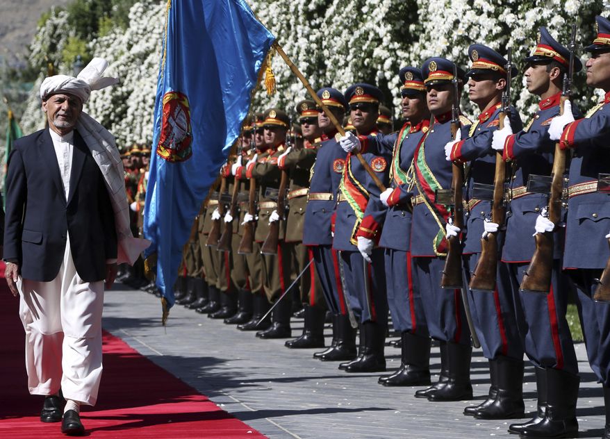 Afghanistan's President Ashraf Ghani, left, inspects the guard of honor as he prepares for Eid al-Fitr prayer at the presidential palace in Kabul, Afghanistan, Tuesday, June 4, 2019. Eid al-Fitr prayer marks the end of the holy fasting month of Ramadan in Afghanistan. (AP Photo/Rahmat Gul)