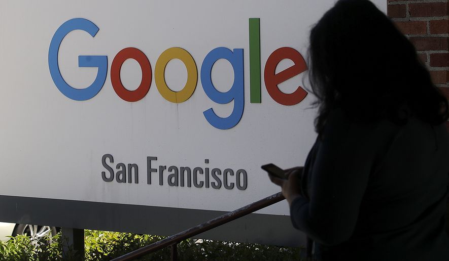 A woman walks past a Google sign in San Francisco, May 1, 2019. The U.S. Justice Department and the Federal Trade Commission are moving to investigate Google, Facebook, Amazon and Apple over their aggressive business practices, and the House Judiciary Committee has announced an antitrust probe of unidentified technology companies. (AP Photo/Jeff Chiu) ** FILE **