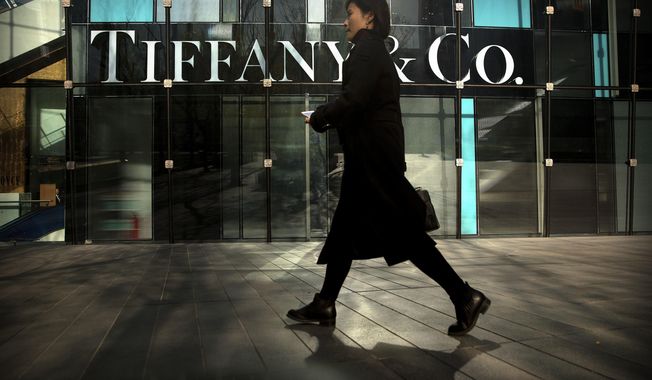 FILE- In this Nov. 29, 2018, file photo, a woman walks past a Tiffany &amp;amp; Co. store at a shopping mall in Beijing. Tiffany &amp;amp; Co. reports financial results on Tuesday, June 4, 2019. (AP Photo/Mark Schiefelbein, File)