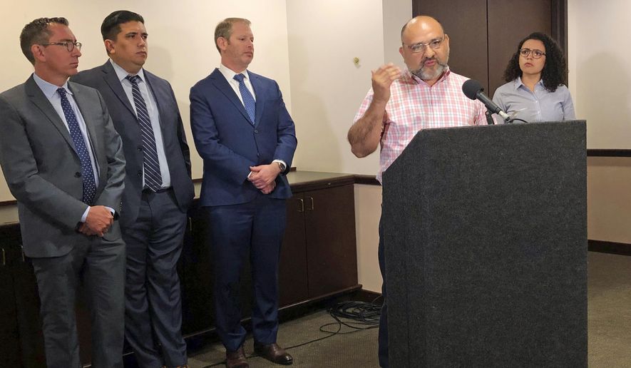 Pastor Angel Campos of Iglesia Monte Vista in Phoenix, at podium, talks Tuesday, June 4, 2019 about feeling afraid and harassed by two anti-immigrant groups who have protested at his church over its aiding immigrant families who have recently arrived at the southern border. The Southern Poverty Law Center is suing the groups to try to stop them. (AP Photo/Astrid Galvan)