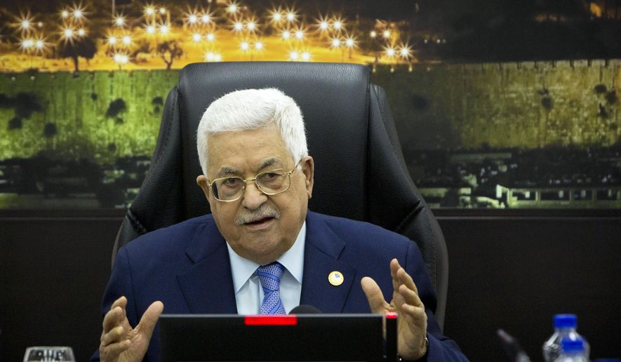 FILE - In this April 29, 2019, file photo, Palestinian President Mahmoud Abbas, center, chairs a session of the weekly cabinet meeting in the West Bank city of Ramallah. Leaked documents showing the Palestinian Cabinet secretly gave itself a generous raise have rocked the West Bank, where the cash-strapped government has been forced to slash the salaries of its employees. The raises were kept secret from the public and approved by President Mahmoud Abbas, two senior officials said, overriding a 2004 law that fixed ministers' salaries. (AP Photo/Majdi Mohammed, Pool, File)
