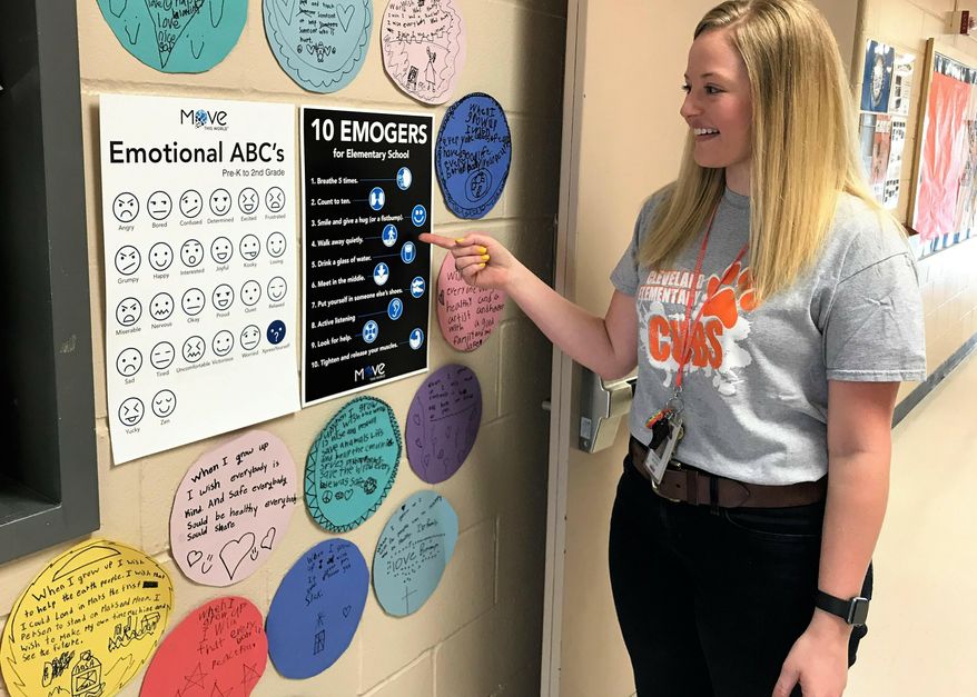 In a Friday, May 10, 2019 photo, Cleveland Elementary teacher Lindsey Olson talks about the emojis used as part of a new emotional well-being program at Sioux Falls School District elementary campuses this year, called Moved This World. With videos and resources dedicated to helping children identify their emotions, Move This World is making it easier for teachers to identify which children might need extra support. (Shelly Conlon/The Argus Leader via AP)