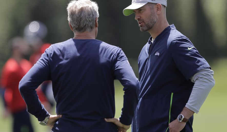 Seattle Seahawks offensive coordinator Brian Schottenheimer, right, talks with head coach Pete Carroll, left, following an organized team activity, Tuesday, June 4, 2019, at the team's NFL football training facility in Renton, Wash. (AP Photo/Ted S. Warren)
