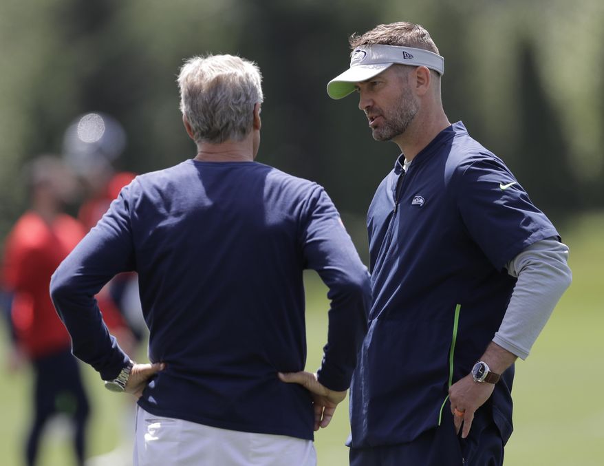 Seattle Seahawks offensive coordinator Brian Schottenheimer, right, talks with head coach Pete Carroll, left, following an organized team activity, Tuesday, June 4, 2019, at the team's NFL football training facility in Renton, Wash. (AP Photo/Ted S. Warren)
