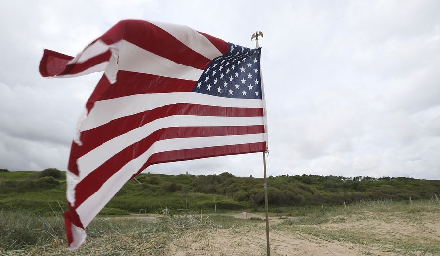An American flag is planted on Omaha beach, Normandy, , Wednesday June 5, 2019. Extensive commemorations are being held in the U.K. and France to honor the nearly 160,000 troops from Britain, the United States, Canada and other nations who landed in Normandy on June 6, 1944 in history&#39;s biggest amphibious invasion. (AP Photo/David Vincent)