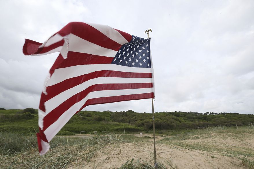 An American flag is planted on Omaha beach, Normandy, , Wednesday June 5, 2019. Extensive commemorations are being held in the U.K. and France to honor the nearly 160,000 troops from Britain, the United States, Canada and other nations who landed in Normandy on June 6, 1944 in history's biggest amphibious invasion. (AP Photo/David Vincent)