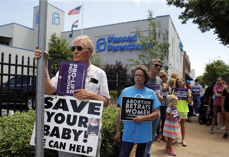 Anti-abortion advocates gather outside the Planned Parenthood clinic Tuesday, June 4, 2019, in St. Louis. A judge is considering whether the clinic, Missouri's only abortion provider, can remain open. (AP Photo/Jeff Roberson)