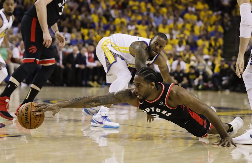 Toronto Raptors forward Kawhi Leonard, foreground, reaches for the ball in front of Golden State Warriors forward Andre Iguodala during the first half of Game 3 of basketball's NBA Finals in Oakland, Calif., Wednesday, June 5, 2019. (AP Photo/Ben Margot) ** FILE **