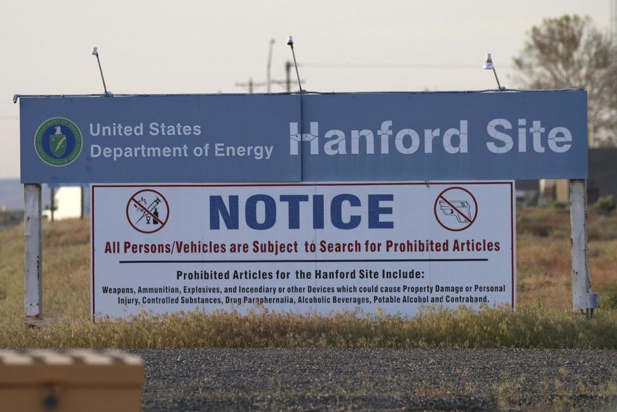 FILE - In this May 9, 2017, file photo, signs are posted at an entrance to the Hanford Nuclear Reservation in Richland, Wash.The state of Washington believes the federal government is unlikely to meet legal deadlines for emptying underground tanks holding radioactive waste at Hanford. The state Department of Ecology says it is prepared to take the U.S. Department of Energy back to federal court to get the cleanup back on track. (AP Photo/Manuel Valdes, File)
