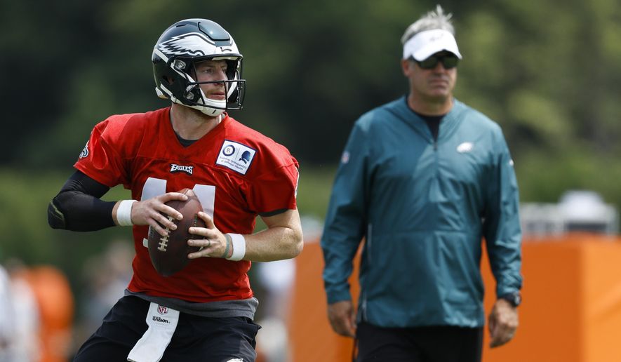 Philadelphia Eagles' Carson Wentz, left, participates in a drill as head coach Doug Pederson looks on during organized team activities at the NFL football team's practice facility, Wednesday, June 5, 2019, in Philadelphia. (AP Photo/Matt Slocum)