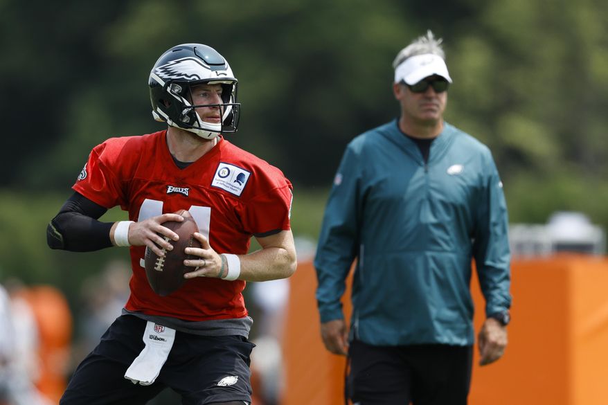 Philadelphia Eagles' Carson Wentz, left, participates in a drill as head coach Doug Pederson looks on during organized team activities at the NFL football team's practice facility, Wednesday, June 5, 2019, in Philadelphia. (AP Photo/Matt Slocum)