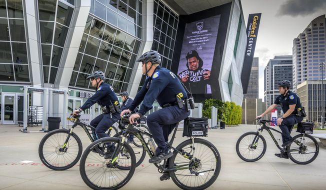 File - In this March 4, 2019, file photo, Sacramento, Calif., police officers ride bicycles near the Golden 1 Center. Organizers of a pride parade in California reversed course and said uniformed police officers will be welcome at the festivities. The announcement came Thursday, June 6, 2019, after the Sacramento LGBT Community Center and Sacramento Police Department created a partnership that will include a police liaison and training for new officers with discussions about bias. (Hector Amezcua/Sacramento Bee via AP, File)