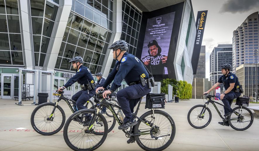 File - In this March 4, 2019, file photo, Sacramento, Calif., police officers ride bicycles near the Golden 1 Center. Organizers of a pride parade in California reversed course and said uniformed police officers will be welcome at the festivities. The announcement came Thursday, June 6, 2019, after the Sacramento LGBT Community Center and Sacramento Police Department created a partnership that will include a police liaison and training for new officers with discussions about bias. (Hector Amezcua/Sacramento Bee via AP, File)
