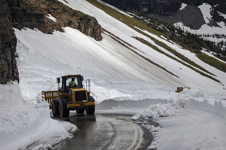 In this photo taken Wednesday, June 5, 2019, an excavator removes remnants of The Big Drift east of Logan Pass on the Going-to-the-Sun Road in Glacier National Park, Mont. Crews finished clearing the 80-foot deep drift Wednesday morning. The road will still need repairs and won't be open to traffic until at least June 22, park officials said. (Sara Diggins/The Missoulian via AP)