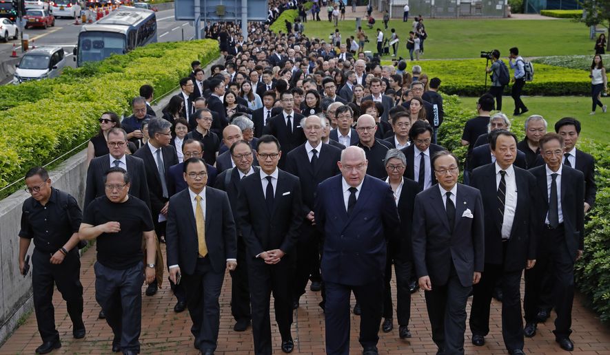 Hundreds of legal professionals wear black to express their disappointment as they participate in a silent march to protest against the extradition bill in Hong Kong, Thursday, June 6, 2019. The extradition law has aroused concerns that this legislation would undermine the city's independent judicial system as it allows Hong Kong to hand over fugitives to the jurisdictions that the city doesn't currently have an extradition agreement with, including mainland China, where a fair trial might not be guaranteed. (AP Photo/Vincent Yu)