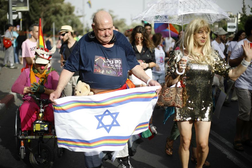 Participants hold flags during the annual Gay Pride parade in Jerusalem, Thursday, June 6, 2019. Thousands of people are marching through the streets of Jerusalem in the city&#39;s annual gay pride parade, a festival that exposes deep divisions between Israel&#39;s secular and Jewish ultra-Orthodox camps. (AP Photo/Ariel Schalit)