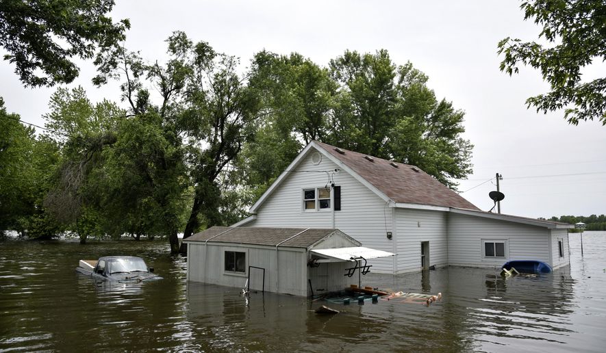 In this Monday, June 3, 2019 photo, a house and pickup truck are submerged in floodwaters as the Missouri River continues to rise in McBaine, Mo. (Kate Seaman/Missourian via AP)