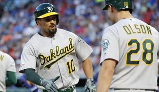 Oakland Athletics&#39; Marcus Semien (10) celebrates with Matt Olson (28) after Semien hit a solo home run during the fifth inning of the team&#39;s baseball game against the Texas Rangers in Arlington, Texas, Friday, June 7, 2019. (AP Photo/Tony Gutierrez)