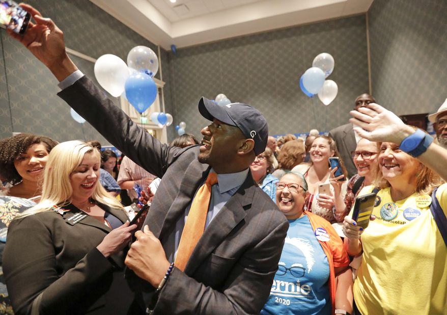 Former Florida Democratic gubernatorial nominee Andrew Gillum, center, takes a photo with supporters during a gathering at the Florida Democratic Party state conference, Friday, June 7, 2019, in Orlando, Fla. (AP Photo/John Raoux)