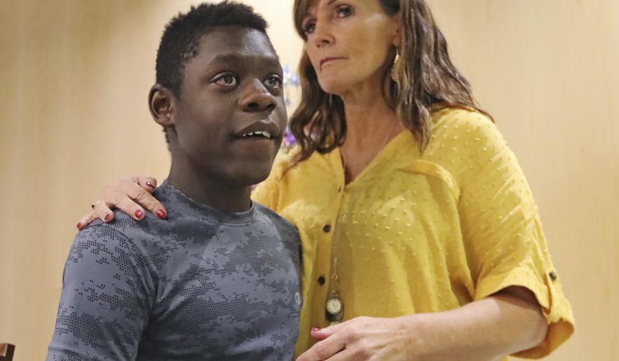 Jerri Hrubes stands next to her son DJ during a news conference Friday, June 7, 2019, in Salt Lake City. Hrubes is calling for an independent investigation after she says a police officer pointed a gun at her 10-year-old son's head in what she calls a racially motivated incident. Hrubes said that a white Woods Cross police officer pulled his gun on her son, DJ, who is black, while he was playing on the front lawn Thursday, June 6, 2019. She says the officer came back to apologize after she called to complain, but that she wants the officer and the agency held accountable. (AP Photo/Rick Bowmer)