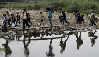 FILE - In this April 14, 2019 file photo, Venezuelans cross illegally into Colombia near the Simon Bolivar International Bridge, close to Cucuta, Colombia. The U.N. refugee agency said Friday, June 7, that the number of Venezuelans who have left their country in recent years has surpassed 4 million. (AP Photo/Fernando Vergara, File)
