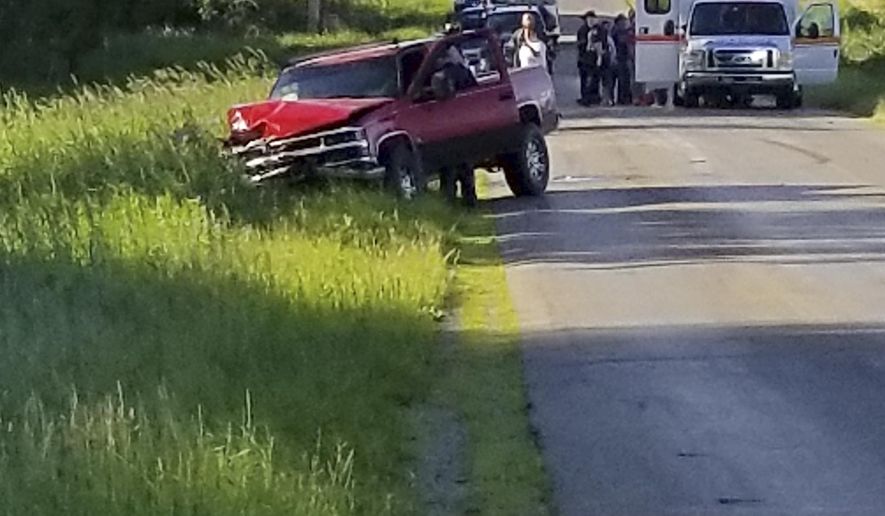 A damaged truck sits on the side of the road after an accident involving a horse-drawn carriage on Friday, June 7, 2019 in California Township, Mich. Michigan State Police said the pick up truck was headed southbound when the driver rear ended an Amish, horse-drawn carriage. Two adults and five children were ejected from the carriage. (Don Reid/The Daily Reporter via AP)