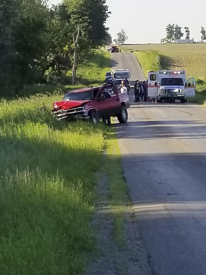 A damaged truck sits on the side of the road after an accident involving a horse-drawn carriage on Friday, June 7, 2019 in California Township, Mich. Michigan State Police said the pick up truck was headed southbound when the driver rear ended an Amish, horse-drawn carriage. Two adults and five children were ejected from the carriage. (Don Reid/The Daily Reporter via AP)