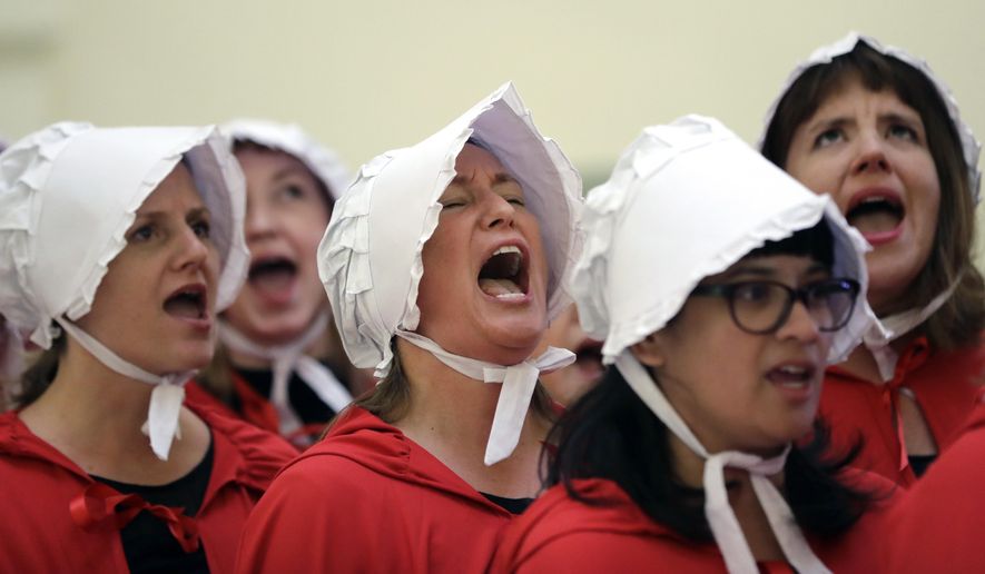 FILE - In this Tuesday, May 23, 2017 file photo, activists dressed as characters from "The Handmaid's Tale" chant in the Texas Capitol Rotunda as they protest SB8, a bill that would require health care facilities, including hospitals and abortion clinics, to bury or cremate any fetal remains whether from abortion, miscarriage or stillbirth, and they would be banned from donating aborted fetal tissue to medical researchers in Austin. Tissue left over from elective abortions has been used in scientific research for decades, and is credited with leading to lifesaving vaccines and other advances. (AP Photo/Eric Gay)