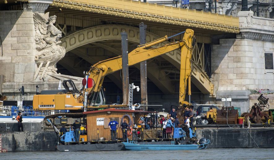 A dredger is stationed at Margaret Bridge during preparations to retrieve the shipwreck of the deadly boat accident in Budapest, Hungary, Friday, June 7, June 2019. A sightseeing boat carrying some 33 South Korean tourists was crashed into by a large river cruise ship and sank on May 29, with 21 people still reported missing and salvage work hampered by poor conditions. (Zoltan Balogh/MTI via AP)