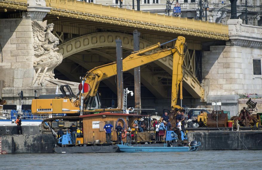 A dredger is stationed at Margaret Bridge during preparations to retrieve the shipwreck of the deadly boat accident in Budapest, Hungary, Friday, June 7, June 2019. A sightseeing boat carrying some 33 South Korean tourists was crashed into by a large river cruise ship and sank on May 29, with 21 people still reported missing and salvage work hampered by poor conditions. (Zoltan Balogh/MTI via AP)