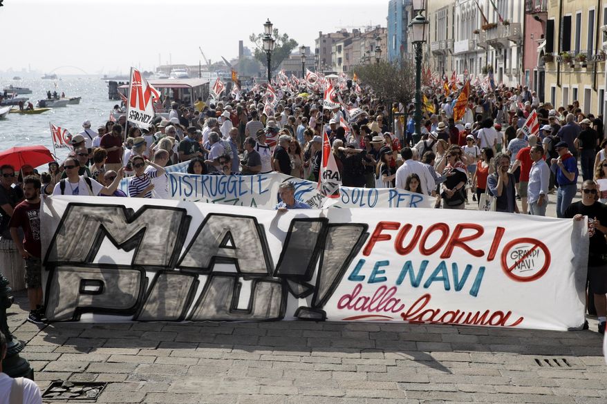 People march during a demonstration against cruise ships being allowed in the lagoon, in Venice, Italy, Saturday, June 8, 2019. Venice environmentalists have long complained that cruise ships displace water, wear down fragile foundations, cause air pollution and damage the delicate lagoon environment by dredging up the muddy bottom. (AP Photo/Luca Bruno)