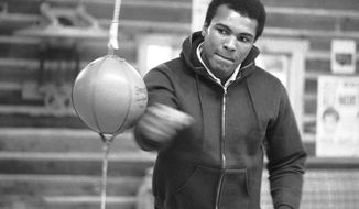 FILE -- In this Jan. 10, 1974 file photo, Muhammad Ali punches a bag in his Deer Lake, Pa., training camp where he was preparing for his rematch with Joe Frazier. The rustic Pennsylvania training camp where Ali prepared for some of his most famous fights has undergone an elaborate restoration. The camp in Deer Lake opened to the public Saturday, June 1, 2019 as a shrine to his life and career. (AP Photo/ Rusty Kennedy)