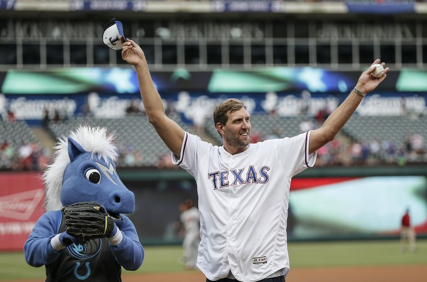 FILE - In this June 5, 2019 file photo, former Dallas Mavericks player Dirk Nowitzki waves to fans after throwing the first pitch before a baseball game between the Baltimore Orioles and the Texas Rangers in Arlington, Texas.  Nowitzki looks relaxed and happy about two months after wrapping up his record 21st season with the same franchise. The big German has been traveling with his family and eating plenty of pizza and ice cream. Nowitzki says he will eventually want to work out again. For now the highest-scoring foreign-born player in NBA history figures he’s at least 20 pounds above his playing weight and not too concerned about it. (AP Photo/Brandon Wade)
