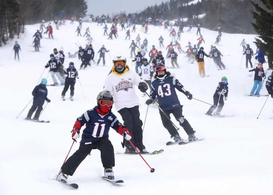 FILE - In this Feb. 3, 2019 file photo, New England Patriots fans head downhill at the Sugarloaf ski resort in Carrabassett Valley, Maine, prior to the NFL Super Bowl football game between the Patriots and the Los Angeles Rams. Thanks to an extended stretch of cold weather, the New England ski industry enjoyed one of best years in recent memory. (AP Photo/Robert F. Bukaty, File)