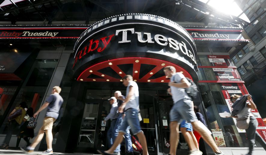 Visitors to New York's Times square walk past a Ruby Tuesday restaurant, Friday, Sept. 16, 2016. Customers have been walking away from sit-down chains as convenience and affordability take precedence. Ruby Tuesday said this week that its CEO is resigning, and the chain forecast another quarter of lower sales as it closes locations. It's the latest of several established restaurant groups that are retrenching, changing management or scrambling to adapt as people have more food choices all around them. (AP Photo/Mary Altaffer)