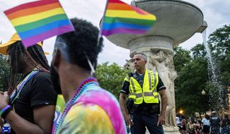 A police officer watches the crowd at the conclusion of the Capitol Pride Parade at Dupont Circle in Washington, Saturday, June 8, 2019. (AP Photo/Andrew Harnik)