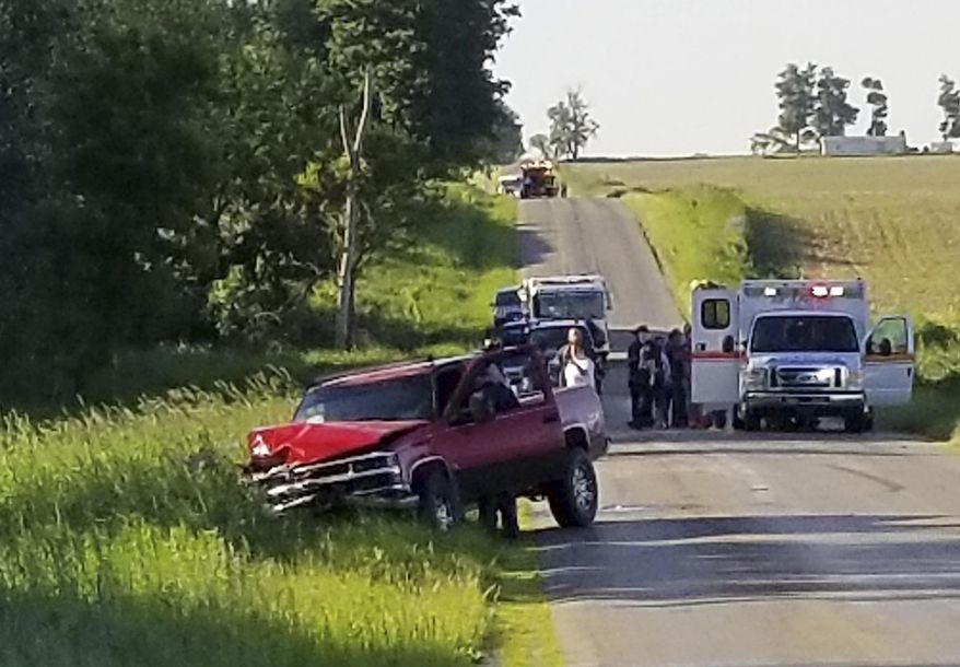 A damaged truck sits on the side of the road after an accident involving a horse-drawn carriage on Friday, June 7, 2019 in California Township, Mich. Michigan State Police said the pick up truck was headed southbound when the driver rear ended an Amish, horse-drawn carriage. Two adults and five children were ejected from the carriage. (Don Reid/The Daily Reporter via AP)