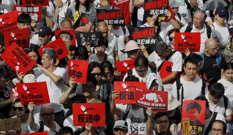 Protesters hold placards march in a rally against the proposed amendments to extradition law in Hong Kong, Sunday, June 9, 2019. The amendments have been widely criticized as eroding the semi-autonomous Chinese territory's judicial independence by making it easier to send criminal suspects to mainland China, where they could face vague national security charges and unfair trials. (AP Photo/Kin Cheung)