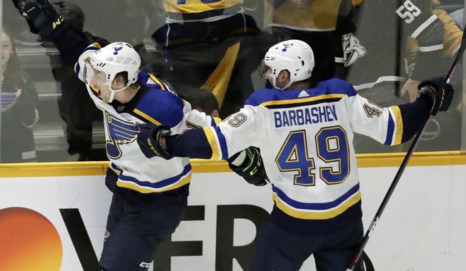 FILE - In this Feb. 10, 2019 file photo, St. Louis Blues right wing Vladimir Tarasenko, of Russia, left, celebrates with Ivan Barbashev (49), of Russia, after Tarasenko scored the winning goal in overtime against the Nashville Predators in an NHL hockey game in Nashville, Tenn. More than two decades since Fetisov and the “Russian Five” shattered the myth that NHL teams couldn’t win with players from a nation unpopular in North America, Tarasenko and Barbashev are one victory away from lifting the same Cup after being inspired by the generation of countrymen who endured so much to get there. (AP Photo/Mark Humphrey, File)