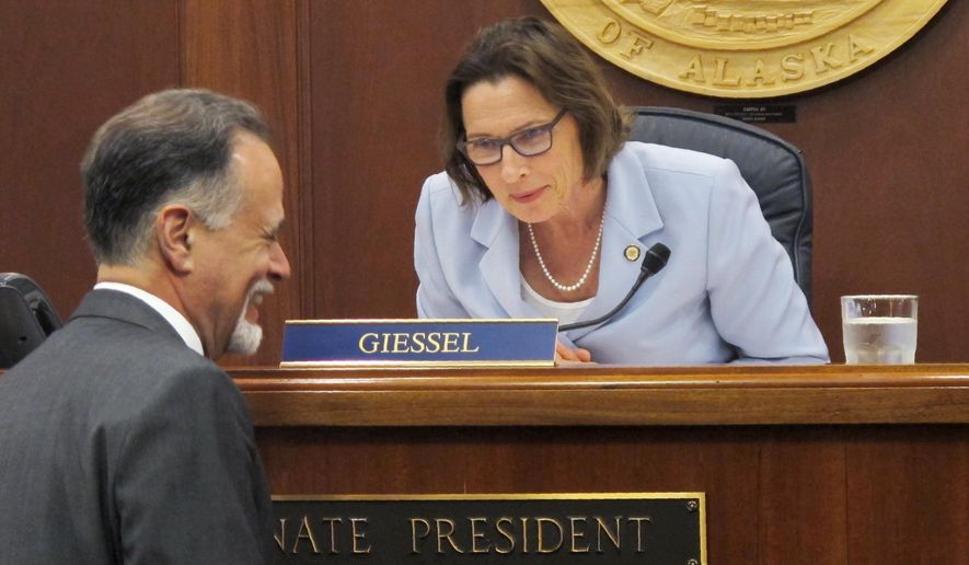 Alaska Senate President Cathy Giessel speaks with Sen. Peter Micciche before the start of the Senate floor session on Monday, June 10, 2019, in Juneau, Alaska. The Senate approved a compromise state operating budget but failed to revive a bill that would pay residents a full dividend this year from the state's oil-wealth fund. (AP Photo/Becky Bohrer)