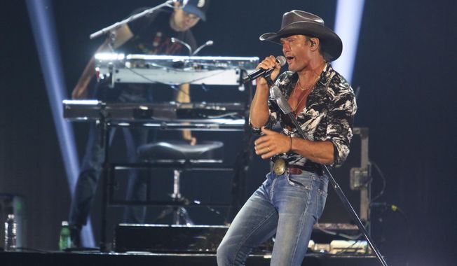 FILE - In this May 4, 2019 file photo, Tim McGraw performs at the iHeartCountry Festival at the Frank Erwin Center in Austin, Texas. The country musician and a political historian may look like an unlikely duo, but McGraw and Pulitzer Prize-winning author Jon Meacham share a common love of history and music. The two wrote “Songs of America: Patriotism, Protest and the Music That Made a Nation,” out Tuesday, June 11 about the impact music has had on American politics, from wars to cultural movements  (Photo by Jack Plunkett/Invision/AP, File)