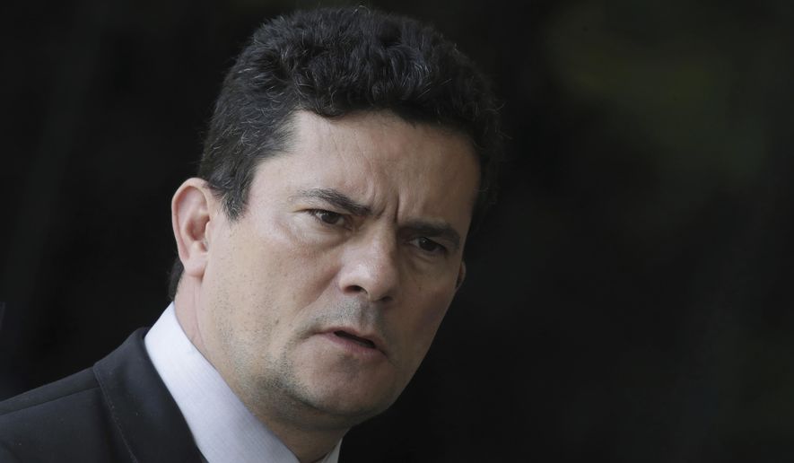 FILE - In this Dec. 4, 2018 file photo, Justice Minister Sergio Moro, who was appointed Justice Minister by President-elect Jair Bolsonaro, speaks to the press as he arrives to Bolsonaro's team transition office in Brasilia, Brazil. The Brazilian Bar Association urged Moro, the justice minister, to step down Monday, June 10, 2019 after a series of reports alleging that as a crusading anti-corruption judge he coordinated with prosecutors in the case that led to the conviction and jailing of former President Luiz Inacio Lula da Silva. (AP Photo/Eraldo Peres, File)