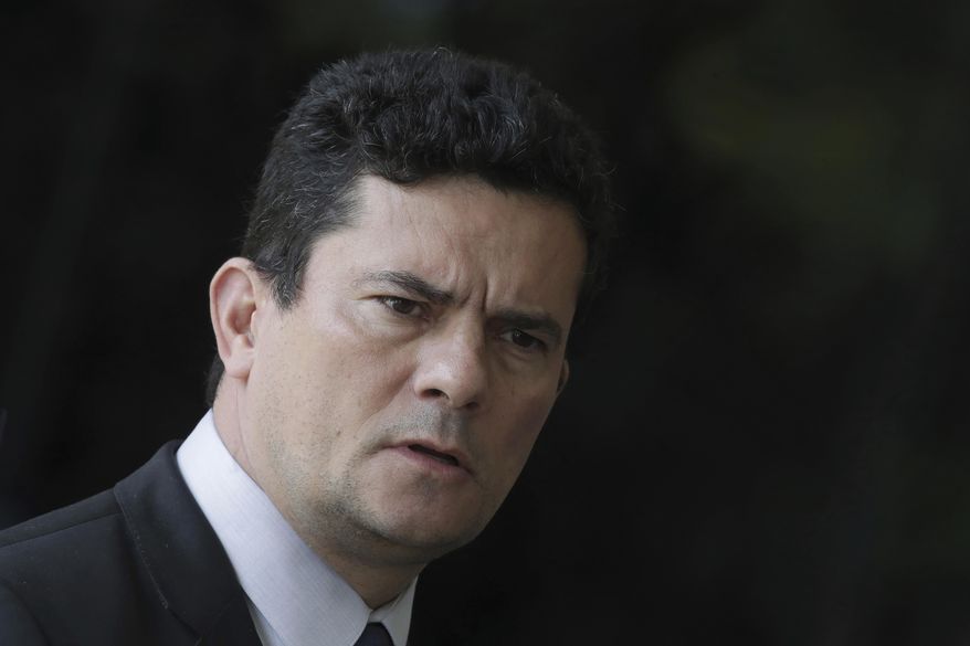 FILE - In this Dec. 4, 2018 file photo, Justice Minister Sergio Moro, who was appointed Justice Minister by President-elect Jair Bolsonaro, speaks to the press as he arrives to Bolsonaro's team transition office in Brasilia, Brazil. The Brazilian Bar Association urged Moro, the justice minister, to step down Monday, June 10, 2019 after a series of reports alleging that as a crusading anti-corruption judge he coordinated with prosecutors in the case that led to the conviction and jailing of former President Luiz Inacio Lula da Silva. (AP Photo/Eraldo Peres, File)